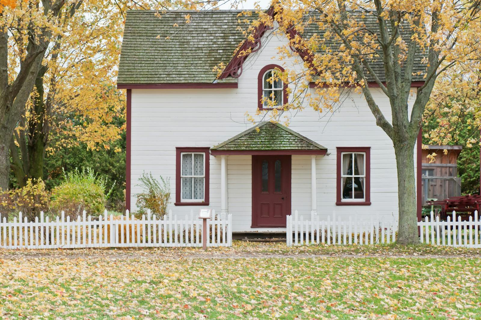 White and Red Wooden House With Fence